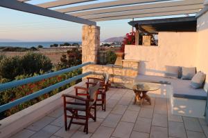 a patio with a table and chairs and a dog at Seaview Ampelas Studio in Ambelas