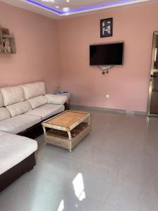 a living room with a couch and a flat screen tv at Résidence saint-Gall-H in Ouidah