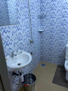 a blue tiled bathroom with a sink and a toilet at Résidence saint-Gall-H in Ouidah