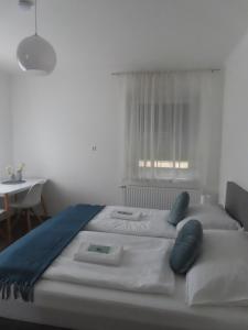 a bedroom with two beds and a table and a window at Apartment Vlora-Naturblick in Villach