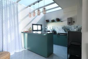 a kitchen with a blue island in a room at Chérie Bliss Loft in Jaipur