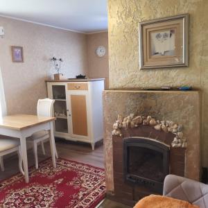 a living room with a fireplace and a table and a dining room at House with a fireplace in Daugavpils