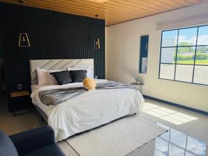 a bedroom with a large bed and a large window at Arenal Star Luxury Studios with Private Jacuzzi in Fortuna