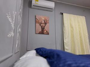 a bedroom with a picture of a woman on the wall at Cilipo House in Palomino +69 photos