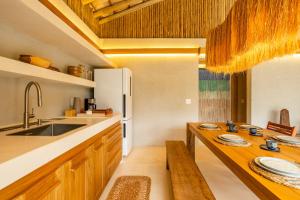 a kitchen with a sink and a wooden table at Casa Água - Praia do Preá in Prea +34 photos