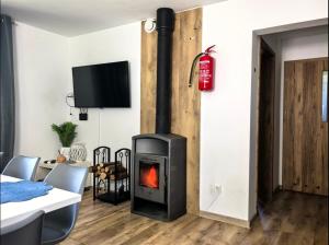 a fireplace in a living room with a table and chairs at SAN ESCOBAR sauna jacuzzi jezioro in Rogowo