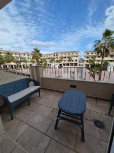 a patio with two chairs and a bench on a balcony at Apartamento Escobar Plaza in Nerja