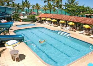 a person swimming in a pool at a resort at Costa Cabralia Hotel in Santa Cruz Cabrália