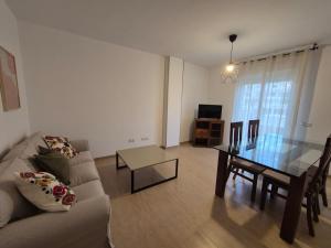 a living room with a couch and a glass table at Apartamento Escobar Plaza in Nerja