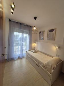 a bedroom with a bed and a large window at Apartamento Escobar Plaza in Nerja