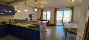 a kitchen with a counter top and a living room at Excellent Appartement S plus 3 in Kelibia
