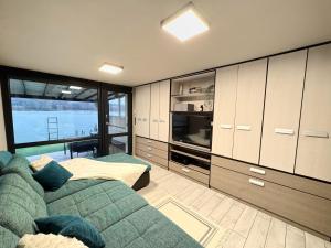 a living room with a couch and a large window at RestOnTheLake in Esztergom