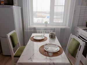 a kitchen with a table with two plates and glasses on it at River Side in Aktobe
