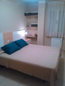 a bedroom with a large bed with blue pillows at Cullera - Primera Línea de Playa in Faro de Cullera +8 photos