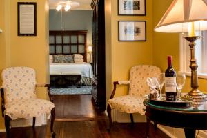 a bedroom with a bed and a table with a bottle of wine at The Marshall House, Historic Inns of Savannah Collection in Savannah
