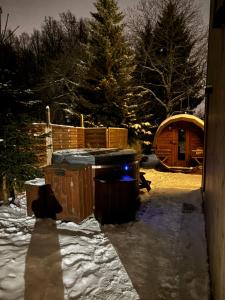 a snowy yard with a hot tub and a wooden cabin at Domek 510 m npm z jaccuzi i sauna in Miłków +4 photos