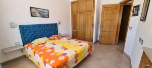 a bedroom with a bed with a blue head board at Excellent Appartement S plus 3 in Kelibia