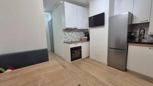 a kitchen with white appliances and a wooden floor at Apartment Ultra-Central, Parcare, AC, Jaluzele, WiFi in Baia Mare