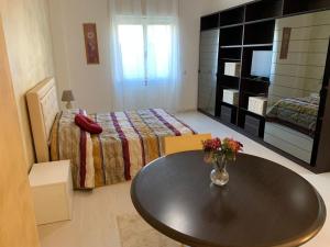 a bedroom with a bed and a table with flowers on it at Casa Roncalli 19 in Foligno