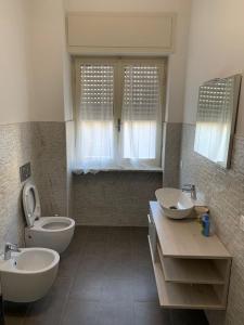 a bathroom with two sinks and a toilet at Casa Roncalli 19 in Foligno