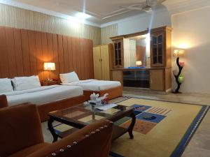 a hotel room with two beds and a coffee table at Executive Royal Garden in Islamabad