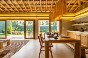 a dining room with a large wooden table with chairs at Casa Água - Praia do Preá in Prea