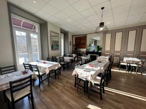 a restaurant with tables and chairs in a room at Hôtel du Midi in Annonay
