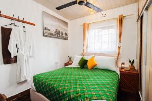 a green and white bed in a room with a window at The Kimaru Cottage in Ngong