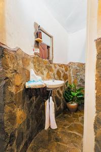a bathroom with a sink in a stone wall at The Kimaru Cottage in Ngong +74 photos