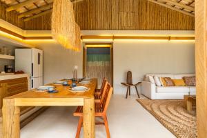 a kitchen and living room with a wooden table and chairs at Casa Água - Praia do Preá in Prea