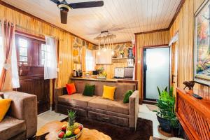 a living room with a couch and a kitchen at The Kimaru Cottage in Ngong