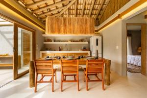 a dining room with a table and chairs and a kitchen at Casa Água - Praia do Preá in Prea