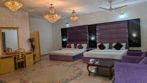 a hotel room with two beds and a table at Executive Royal Garden in Islamabad +21 photos