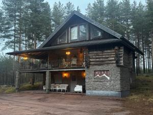 a log cabin in the woods with a balcony at Lepohetki in Loimaa