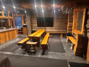 a room with a table and benches and a tv at Lepohetki in Loimaa