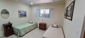 a bedroom with a bed and a table and a mirror at Recanto do Nenei in Paraisópolis