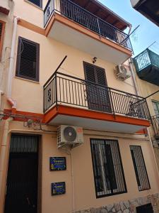 an apartment building with a balcony and a fan at Fabian Appartament in Bagheria +5 photos