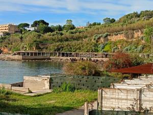 a body of water with a building on a hill at Fabian Appartament in Bagheria