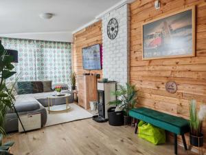 a living room with a bed and a clock on a wall at Horizon Hill in Cserszegtomaj