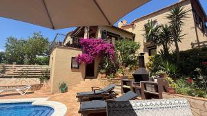 a house with a swimming pool and an umbrella at Bellavista in Begur