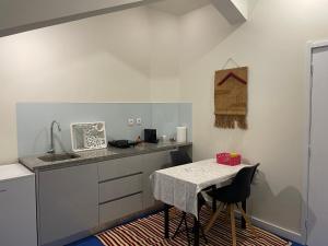 a kitchen with a table with chairs and a counter top at Easy Stay In Espinho in Espinho +6 photos