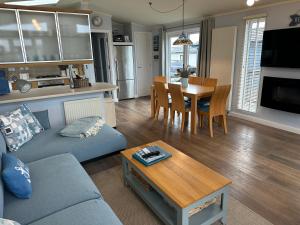 a living room with a couch and a table at Driftwood Lodge in Salcombe