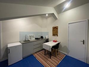 a small kitchen with a table and a sink at Easy Stay In Espinho in Espinho