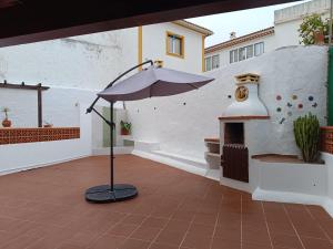 a patio with an umbrella and a fireplace at MiRaRio in Vila Nova de Milfontes