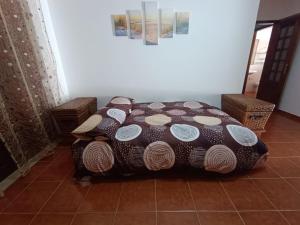 a bed sitting on a tiled floor in a room at MiRaRio in Vila Nova de Milfontes