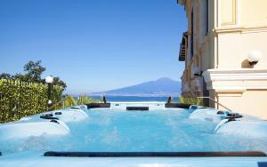 a hot tub outside of a building with the ocean in the background at La Terrazza De Luxe in Sorrento