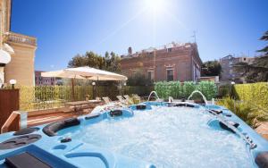a hot tub in a yard with chairs and an umbrella at La Terrazza De Luxe in Sorrento