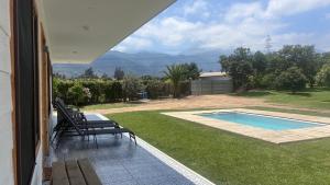 a patio with chairs and a swimming pool with a view at Florencia Boutique Cabin in Olmué