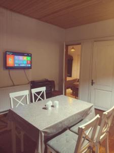 a room with a table and chairs and a tv at Apartment of mestia in Mestia