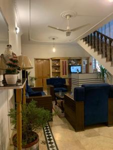 a living room with blue furniture and a staircase at Executive Royal Garden in Islamabad